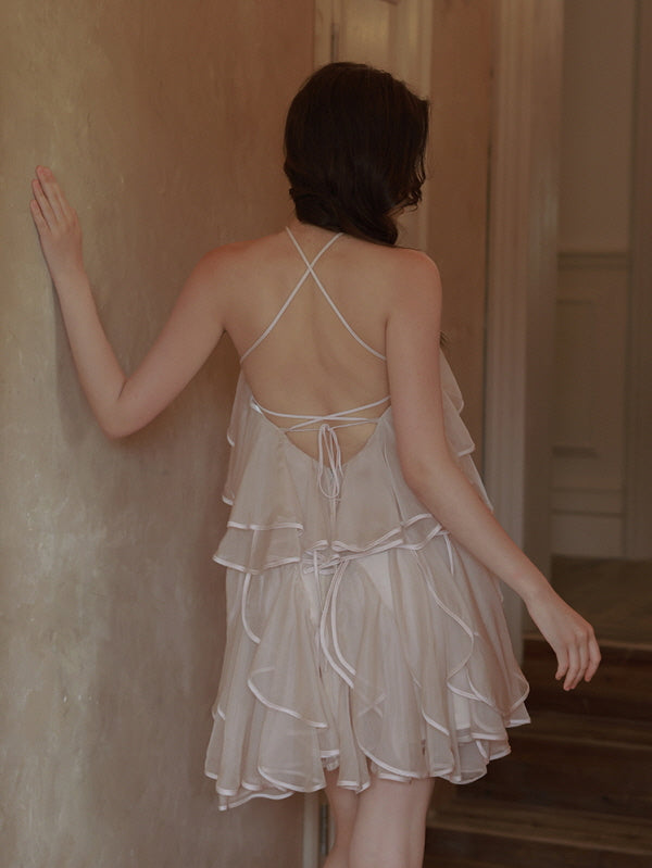 The back view of a ruffle mini dress reveals delicate crisscross straps and soft layers, embodying a dreamy and feminine princesscore aesthetic.