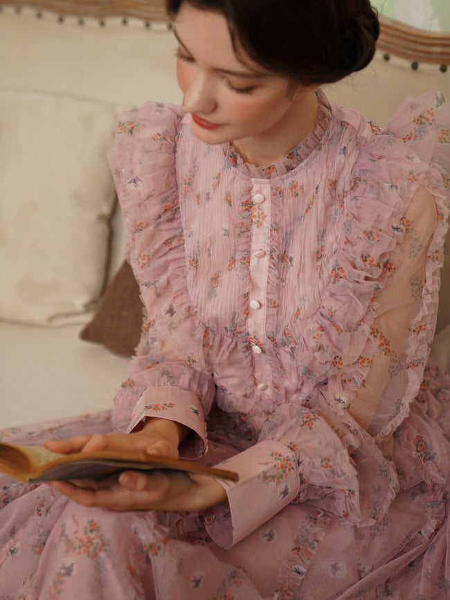Close-up of a pink fairycore dress with soft ruffles and floral cuffs as the model reads quietly, evoking a nostalgic and romantic feeling.