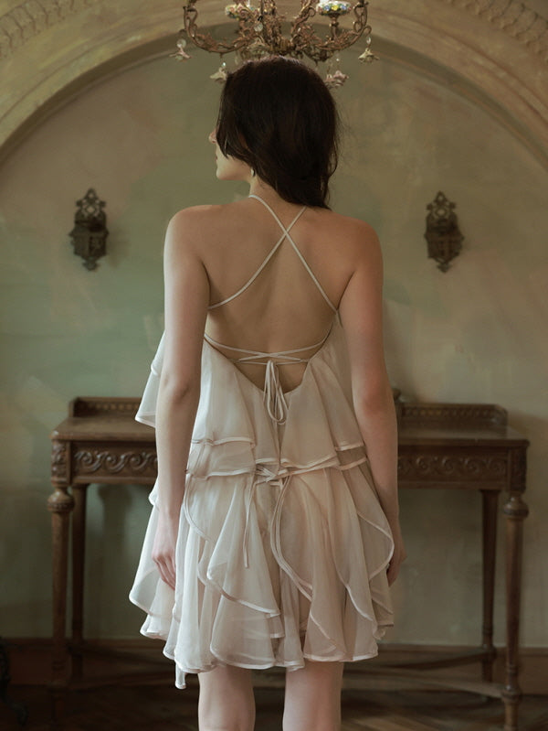 Back view of a delicate strappy dress with layered ruffles, highlighting the romantic silhouette and dreamy details of the fairycore design.
