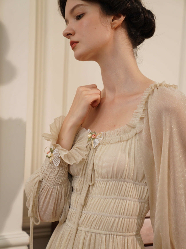 Close-up of a model in a ruched cream dress with floral bow details and soft shimmer, evoking a serene and timeless fairytale mood.