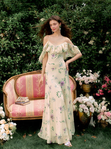 The model smiles softly while holding her floral dress in a garden setting, radiating a lighthearted summer charm with a romantic princesscore mood.