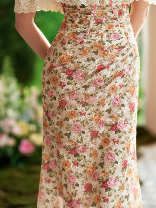 Detailed view of the ruched floral fabric and flowing silhouette, highlighting vintage charm and soft romantic textures in a garden setting.
