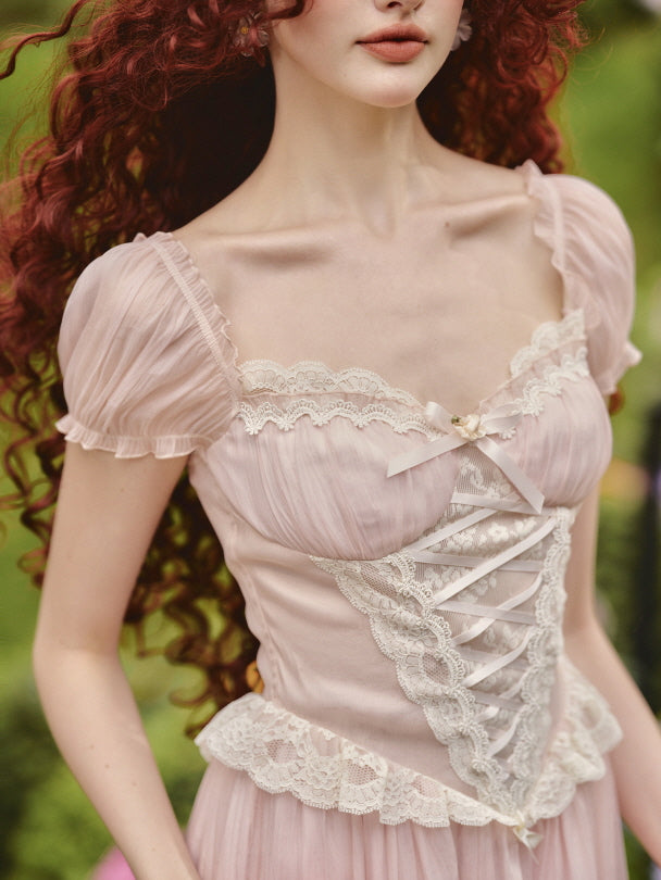 A close-up of a model wearing a pink fairytale corset dress with lace trim and puff sleeves, perfect for a romantic princesscore outfit.