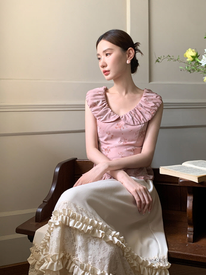 Sitting quietly in a vintage room, the model wears a rose pink ruffle top and cream lace skirt, styled with soft cottagecore elegance.