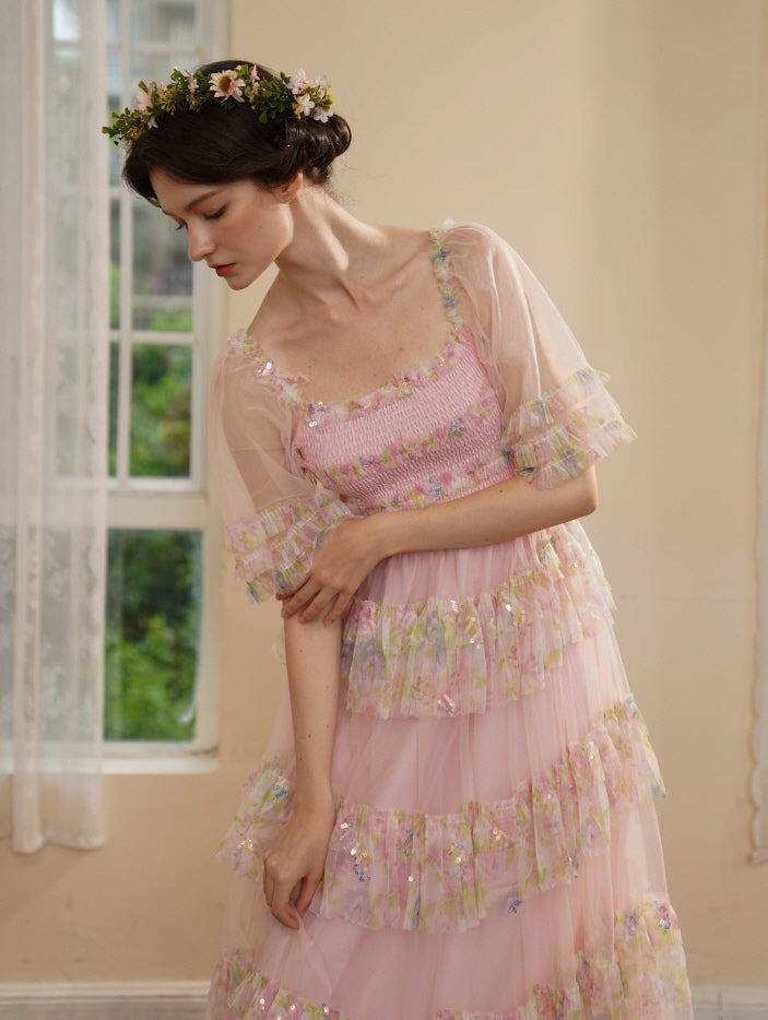 Model in a sequin-ruffled pastel pink dress bows gently in a serene moment, capturing an ethereal princesscore mood by the window.