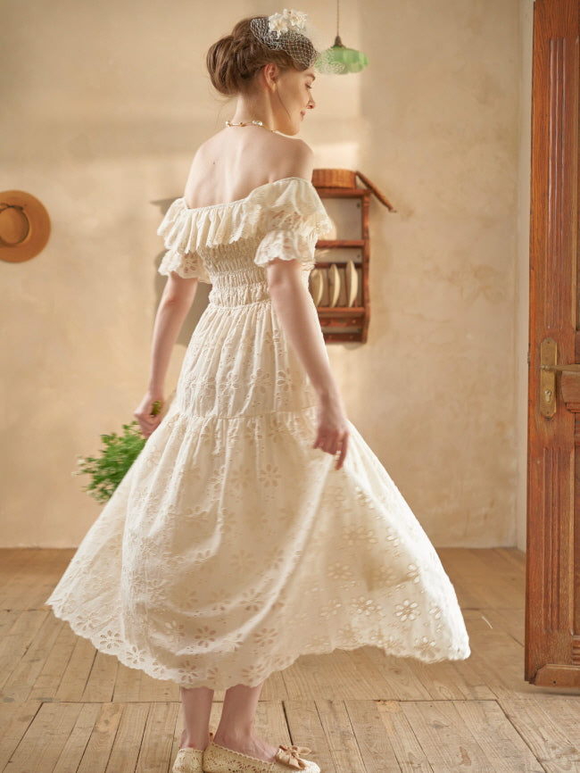 A woman twirls gracefully in a cream eyelet dress, revealing the soft flow of the skirt in a romantic vintage-style interior.