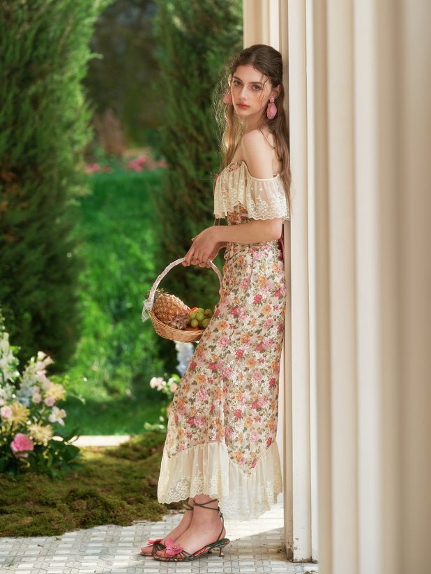 The model leans softly against a column in a vintage floral dress, holding a basket of fruit and radiating fairycore elegance in the garden.