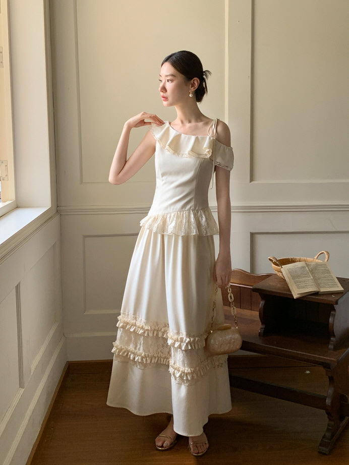 In a soft ivory two-piece set with frill accents, the model gazes out the window holding a textured bag, styled with romantic princesscore charm.