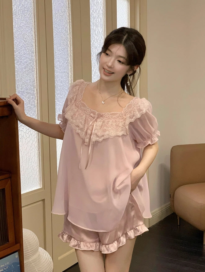Woman smiling softly in a princesscore loungewear set featuring layered cute pink chiffon, puff sleeves, and delicate lace trim, styled for a dreamy night in.