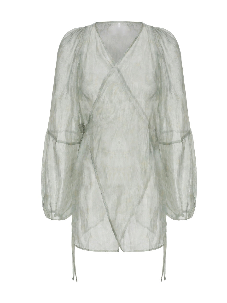 Flat lay of a sheer puff-sleeve wrap blouse in pale green, perfect for layering with fairycore or vintage-inspired outfits.