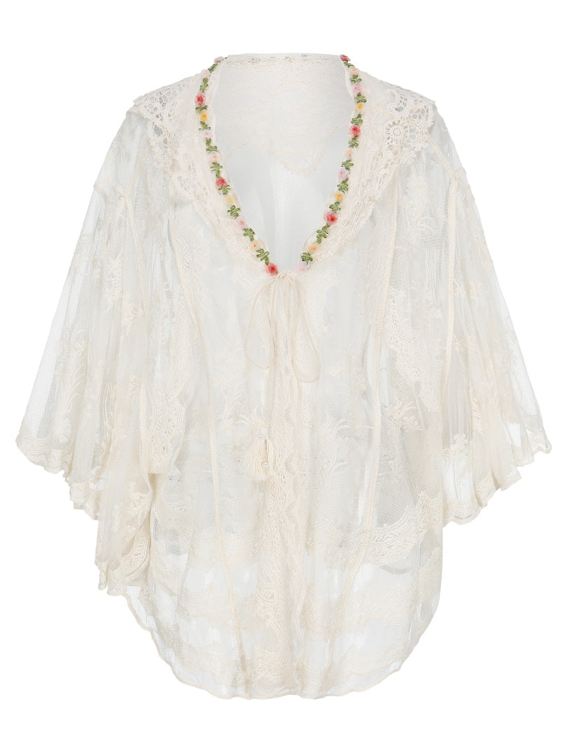 Flat lay of a vintage-inspired lace outerwear blouse with ruffle sleeves and a floral trim neckline, perfect for a cottagecore or fairycore wardrobe.